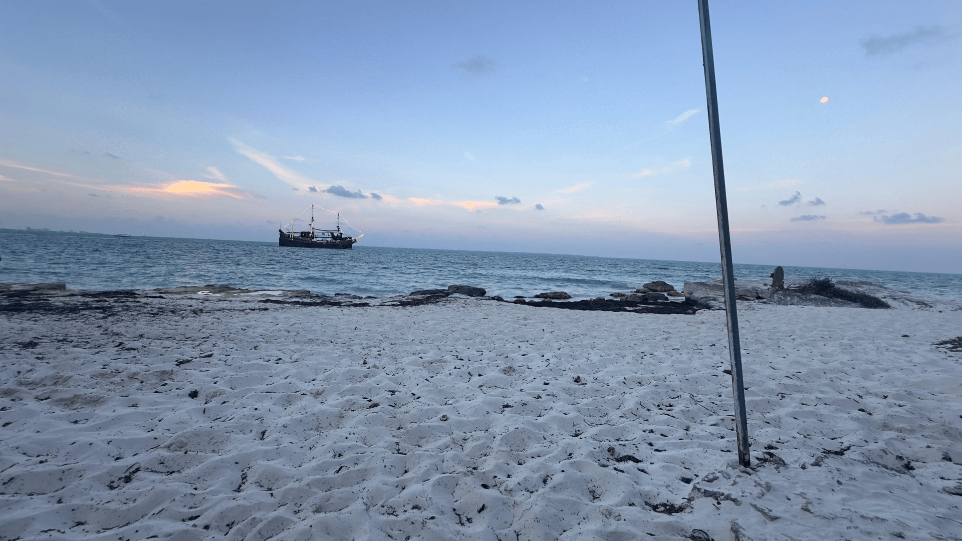 Fondo de playa y mar Caribe con un barco de tours en Cancun