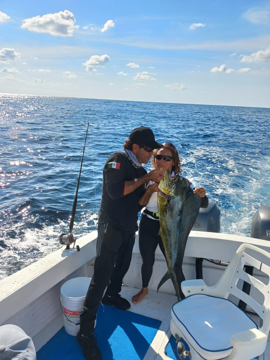 capitan y cliente felices en tour de pesca en isla mujeres